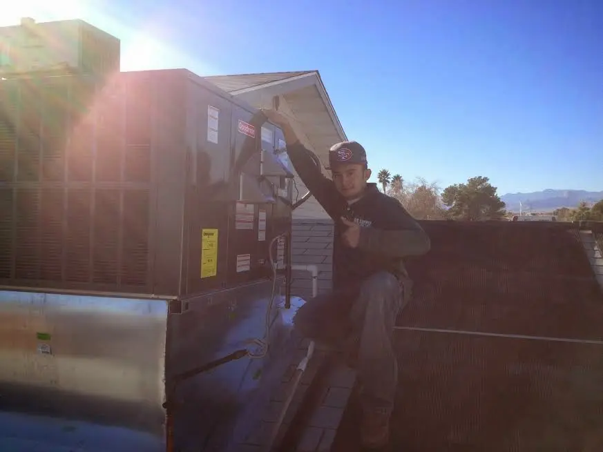 HVAC technician performing Air Duct Repair on a rooftop unit in Goshen